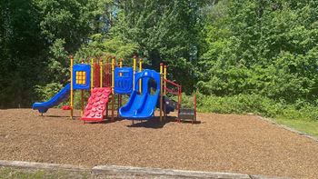 a playground with a blue and red swing set